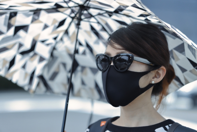 日傘を持つサングラスの女性